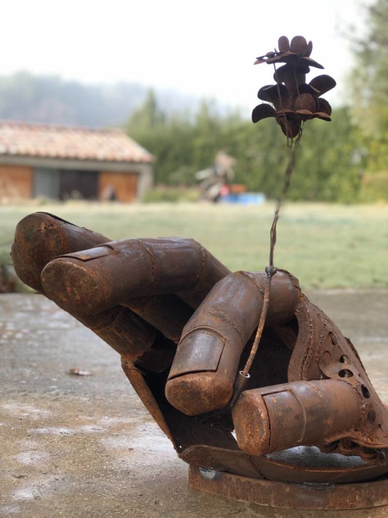 Sculpture représentant une main faite à partir d'éléments en métaux de récupération