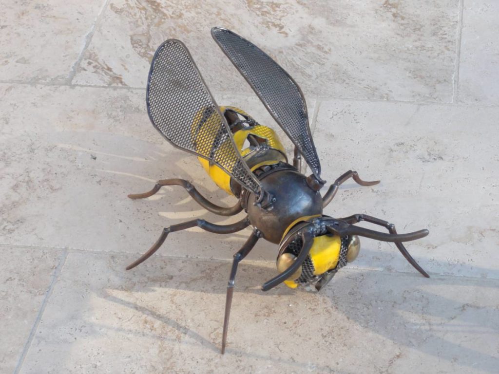 Guêpe ou abeille fabriquée à partir d'éléments de récupération en métal. Tôle jaune, morceau de chaine,.