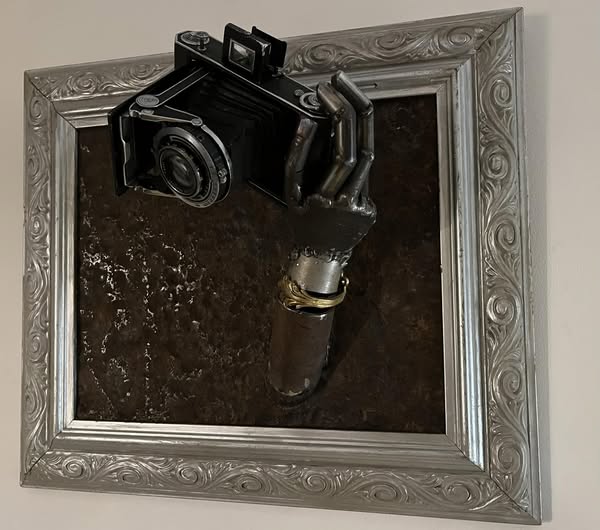 réalisée avec un ancien appareil de photo récupéré et un cadre en bois