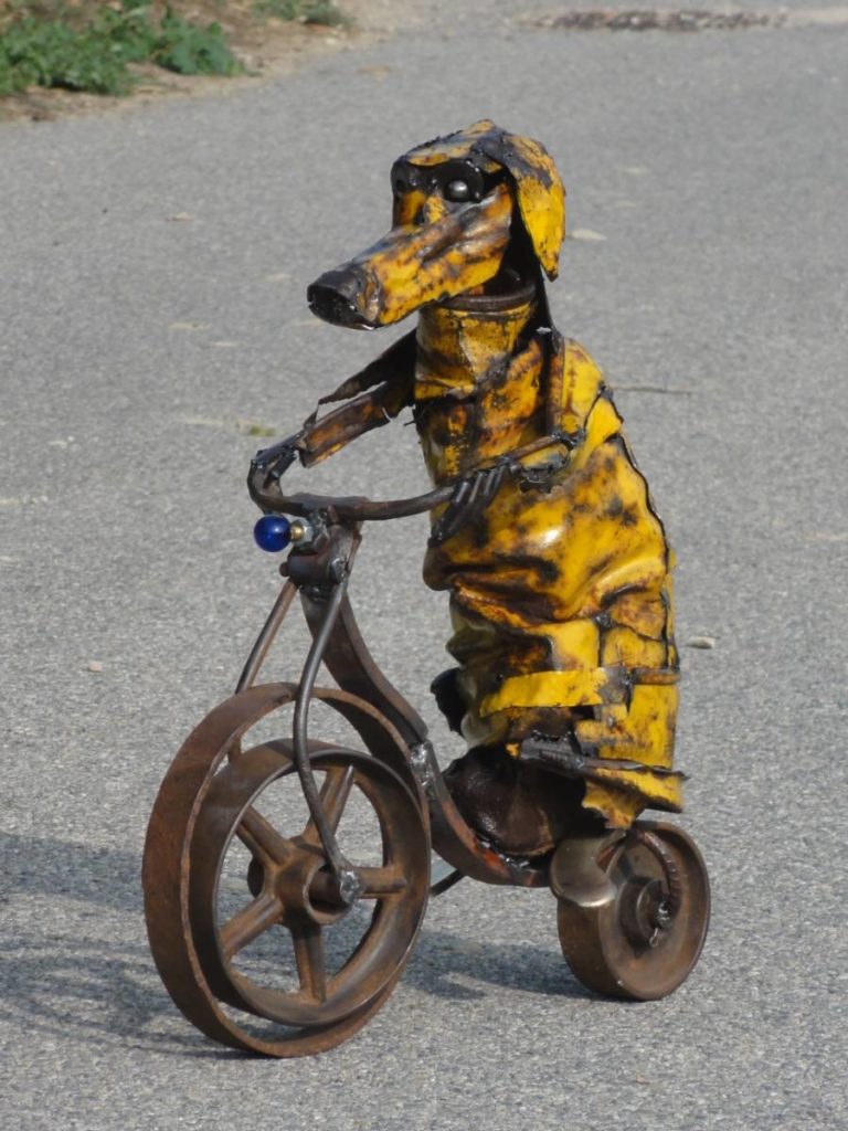 Chien jaune fait avec un vieux tonneau froissé , des roues de charrettes, une ampoule