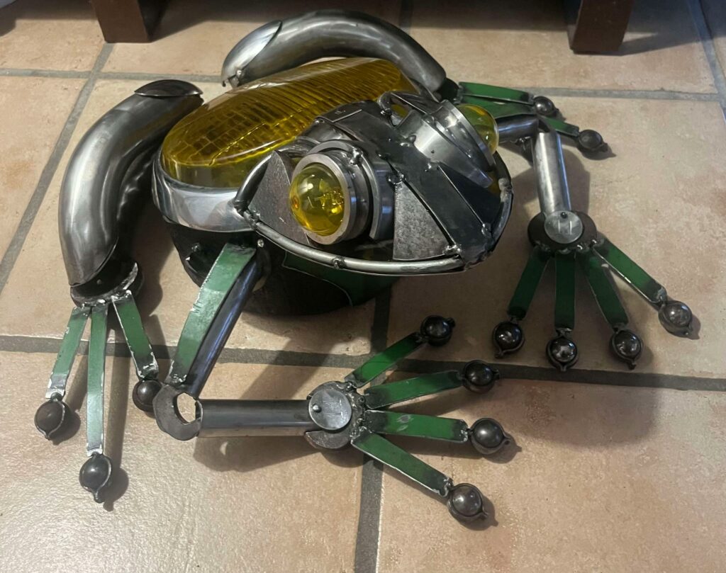 grenouille métal réalisée avec un ancien phare , des vieux outils et des pièces mécanique
