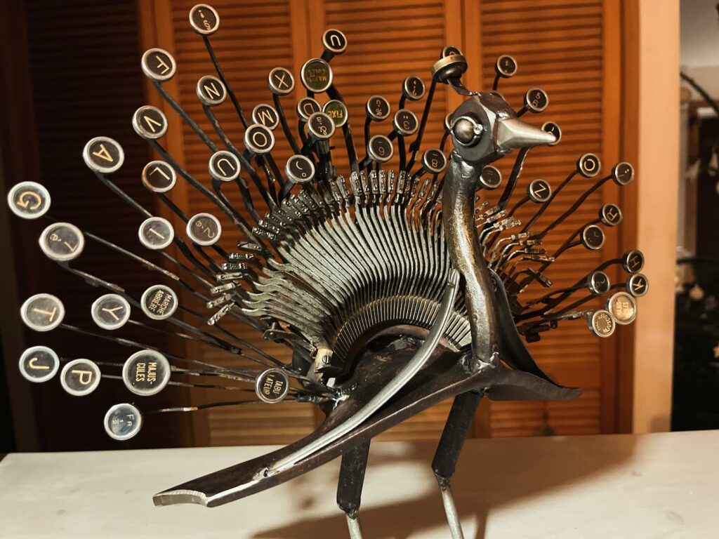 sculpture réalisée avec une ancienne machine à écrire et des vieilles fourchettes et des éléments agricoles