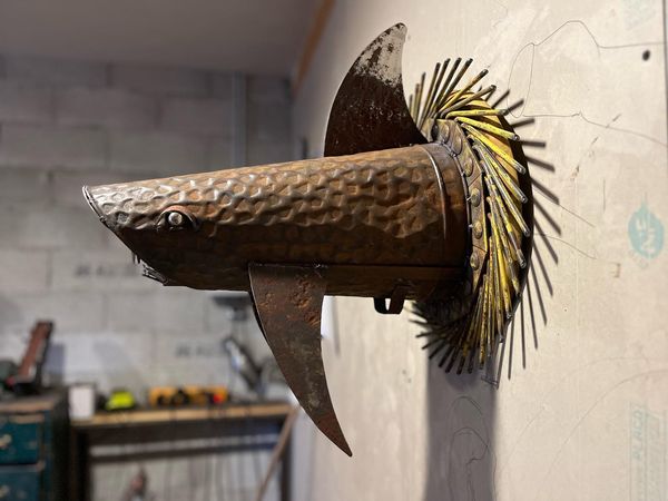 soudé et réalisé à partir d'une ancienne roue agricole, et d'un chaudron à charbon